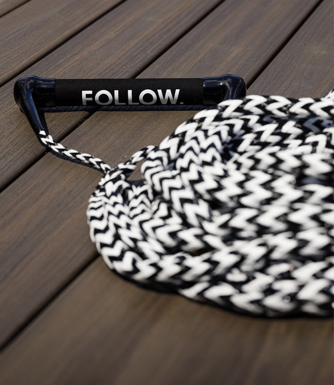 Follow Surf Package Black/White wakesurf rope and handle in use behind the boat on the wave