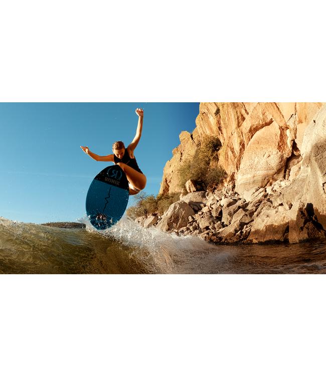 Ronix Moment Womens Skimmer - rider airing off the top of the wave beside a rocky cliff