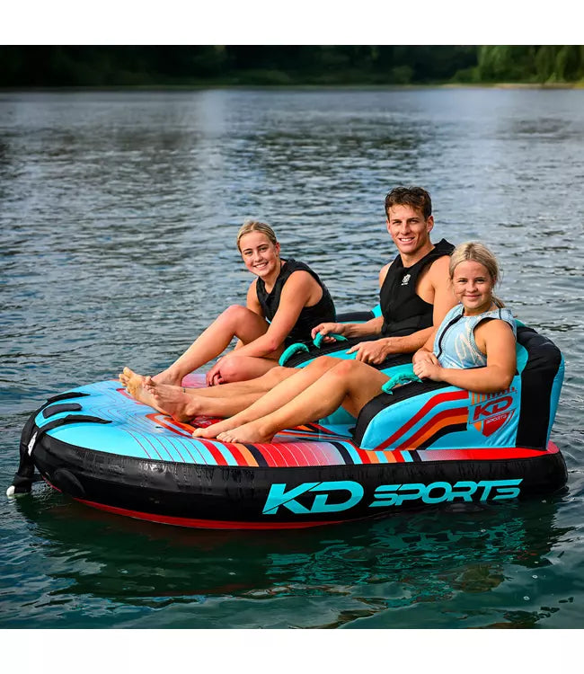 KD Lazyboy 3 3-person couch ski tube - lifestyle shot of three riders on the water behind a boat