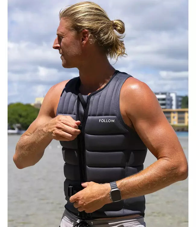 Follow Total Grey Mens Life Vest worn by a wakeboarder riding behind the boat on open water