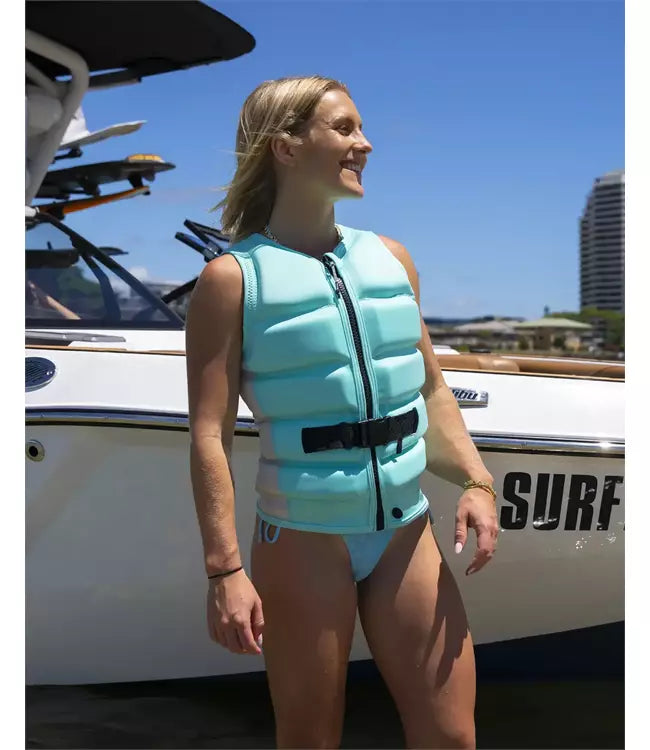 Follow Corp Mint Womens Life Vest worn by a woman riding behind the boat on open water