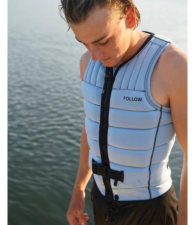 Follow Total Light Blue Mens Life Vest worn by a wakeboarder riding behind the boat