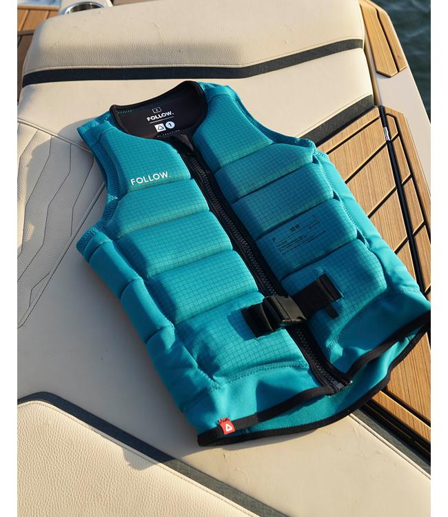Follow P1 Traction Emerald Mens Life Vest worn by a wakeboarder riding behind the boat