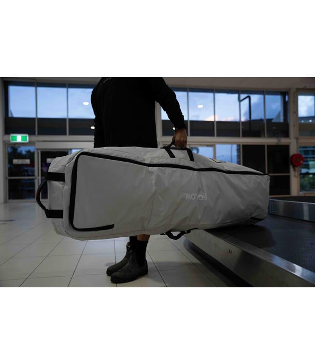 Follow Life Board Travel Bag in Light Grey – lifestyle shot showing rider carrying the wheeled board bag
