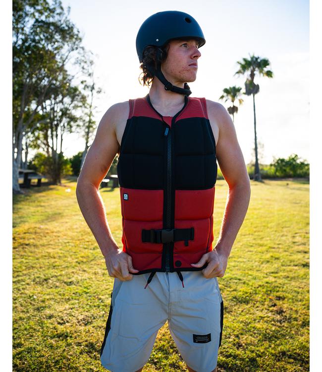 Follow Gratis Rust Mens Life Vest worn by a wakeboarder riding behind the boat on open water