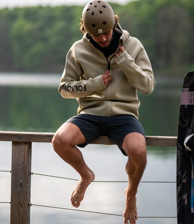 Follow Company Neo Jacket Khaki worn by a rider staying warm between sets on the boat