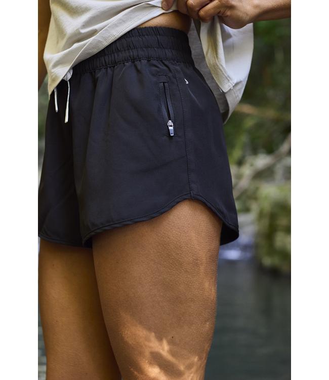 Follow Odessa Womens Board Shorts Black worn on the water during a wakeboarding day