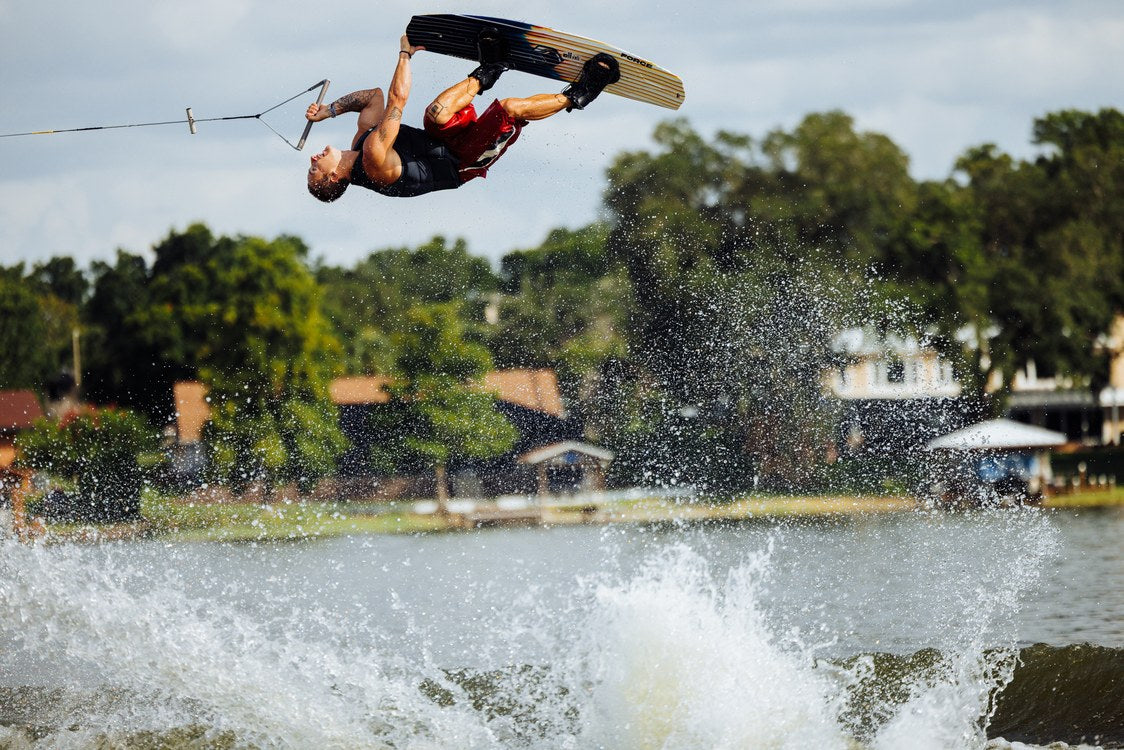 Liquid Force Trip Wakeboard Package on a rider boosting a jump off the wake
