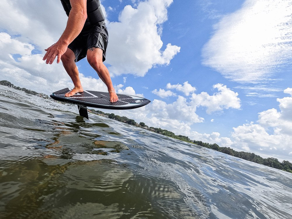 Liquid Force X Foil Board on a rider riding the foil across flat water