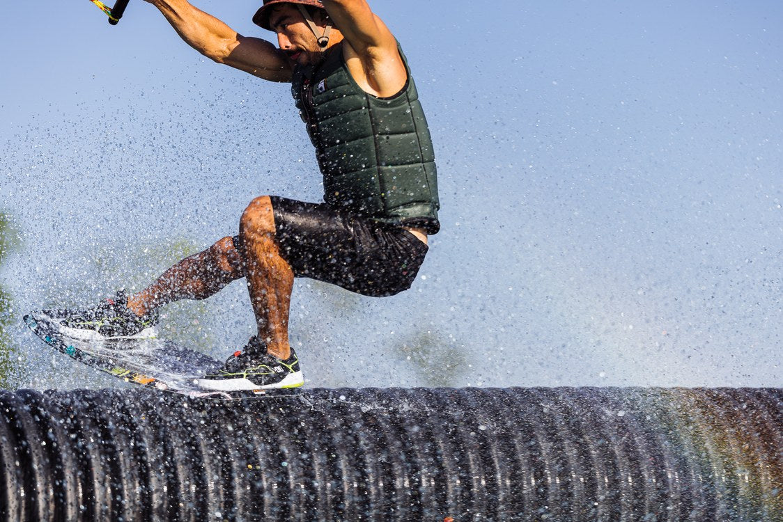 Liquid Force Tao Wakeskate on a rider approaching a cable park feature on the water