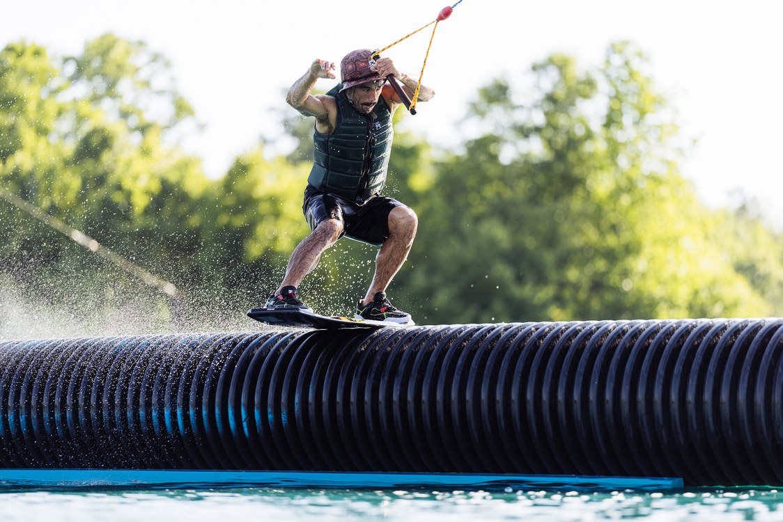 Liquid Force Tao Wakeskate on a rider popping the board off the water at the cable park