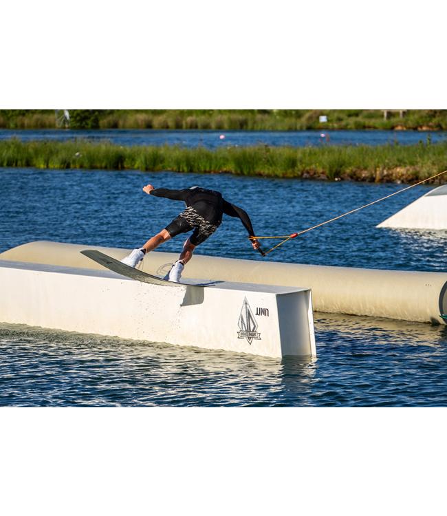 Ronix Utopia Cable Wakeboard - rider sliding a white box obstacle at a cable park