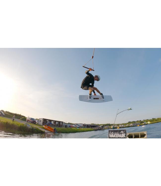 Ronix Utopia Cable Wakeboard - rider mid-air backlit by low sun over the cable park lake