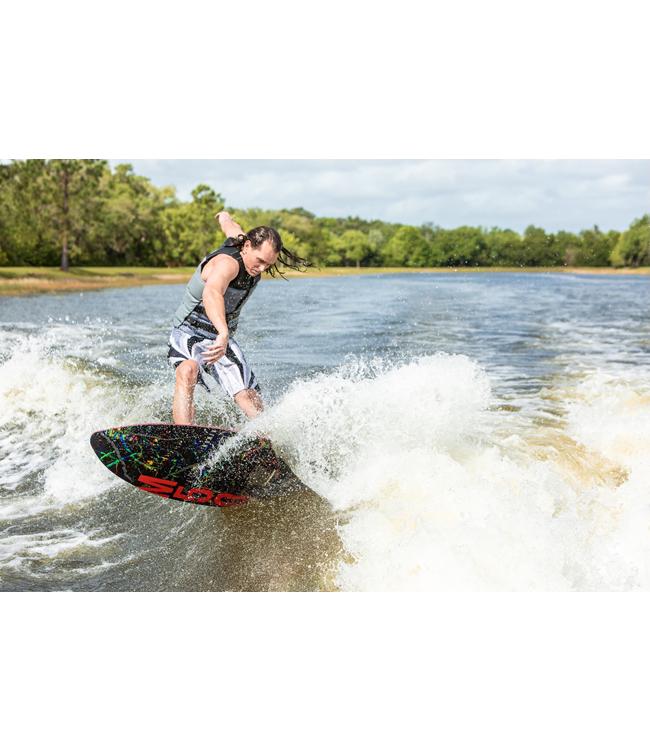 Ronix M50 Dark Matter Wakesurfer - rider driving a bottom turn with a treeline on the bank