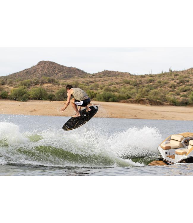 Ronix Osmo Skimmer - rider carving hard beside the boat below a dry desert bank