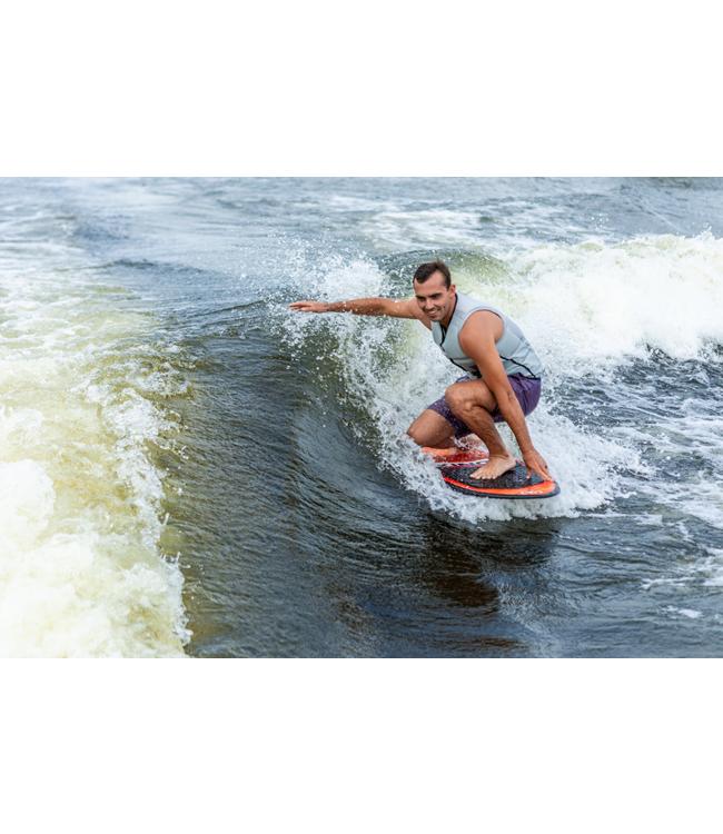 Ronix South Shore Skimmer - rider carving across the wave with a treeline on the bank