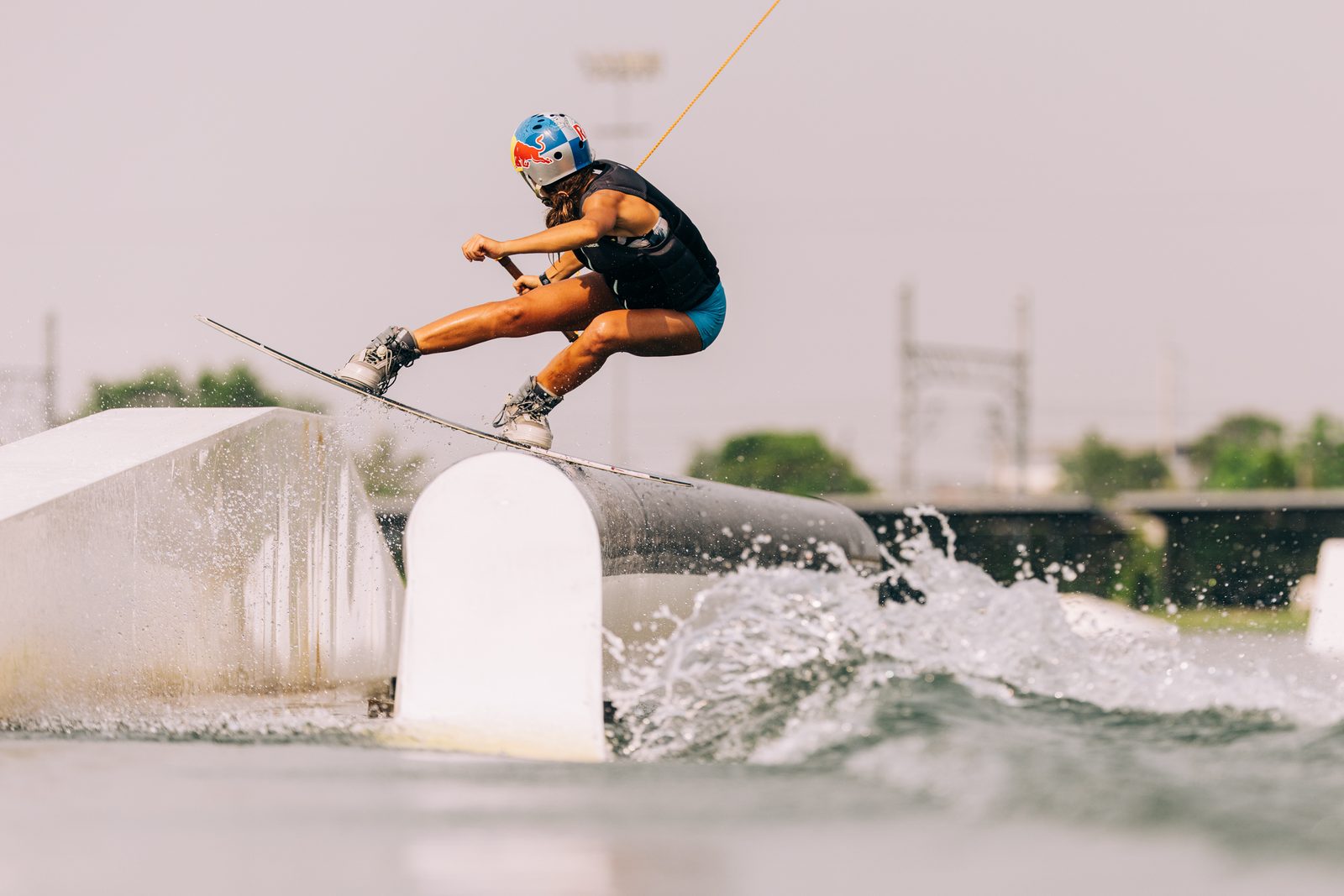 Cable park wakeboarder pressing a rail